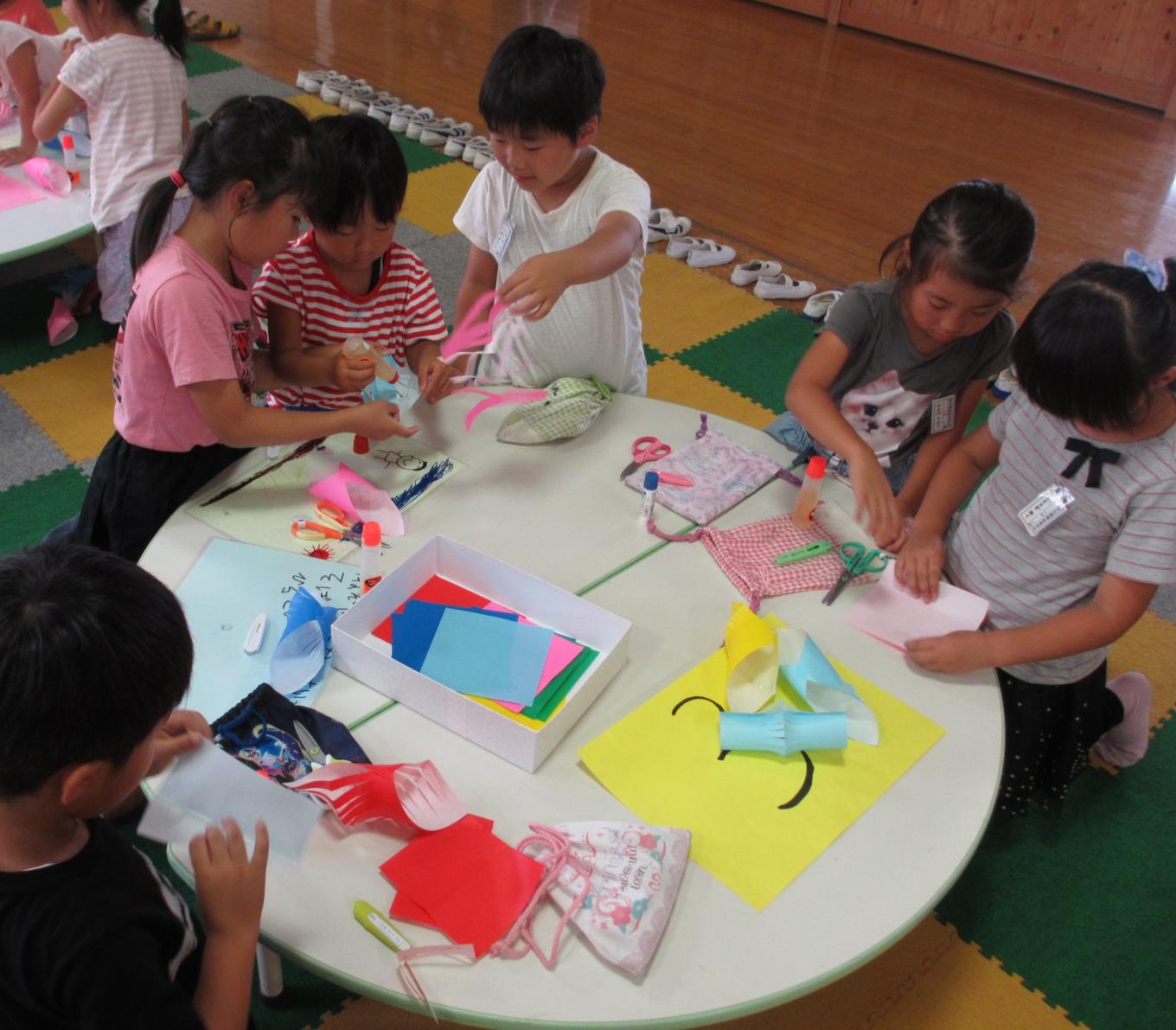 幼稚園生に飾りの作り方を教える2年生