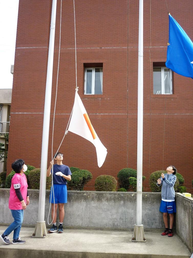 国旗降納をする6年生児童