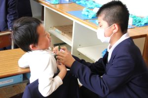 コサージュを付けてもらう男子