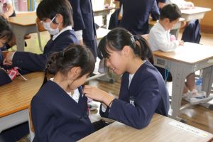 コサージュを付けてもらう女子