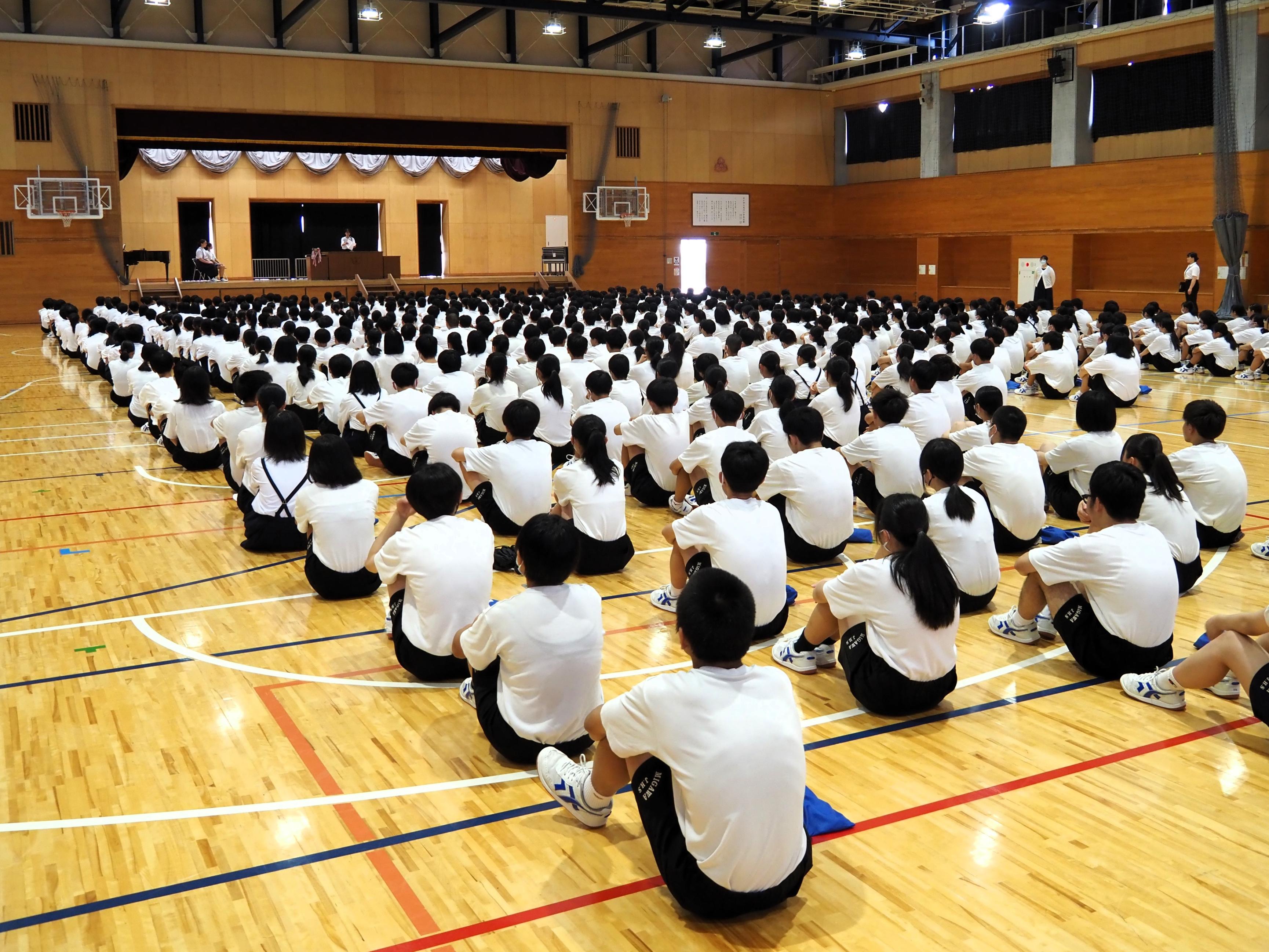 01 しっかりした態度で生徒代表の作文を聞いています