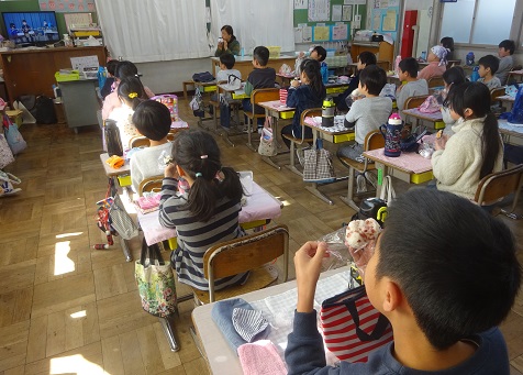 給食の放送を見ながらおにぎりぱくっ