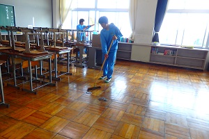 3年生の教室を掃除する1年生
