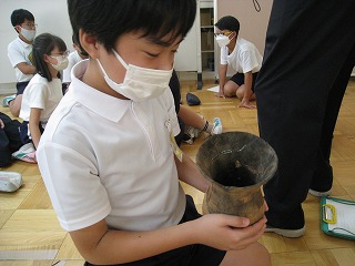 土器を手に取ってみる児童(1)