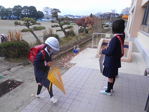 昇降口であいさつする児童