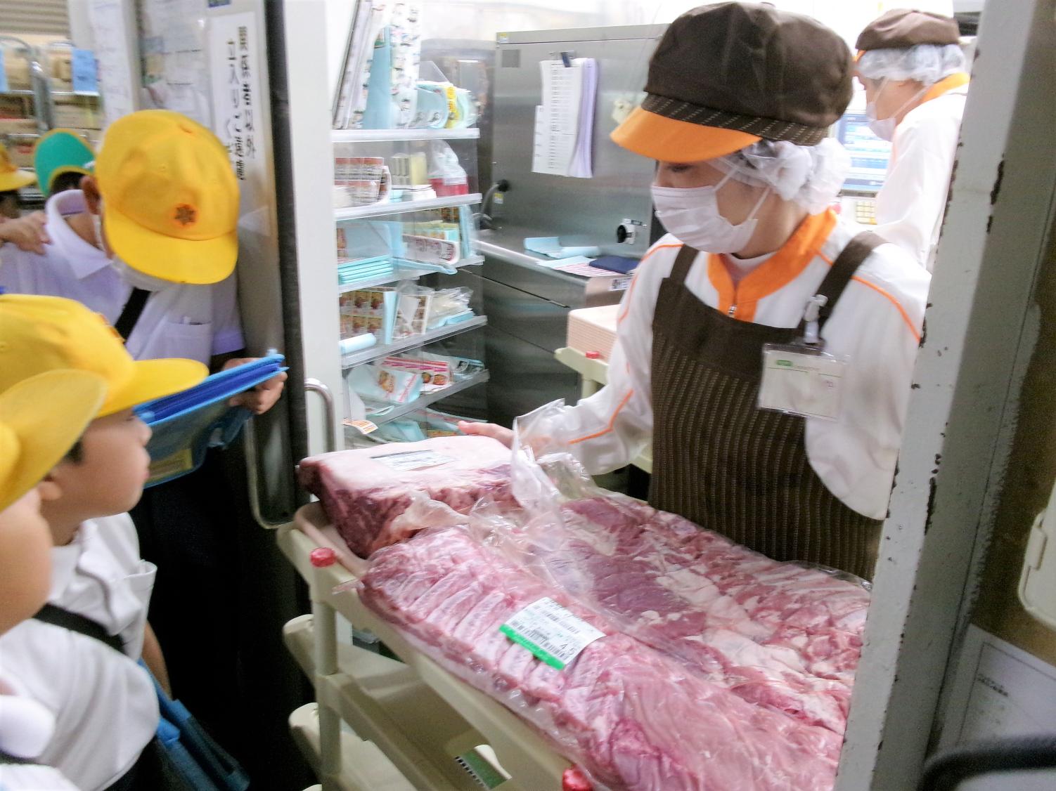 お肉のかたまりをお店でスライスしています