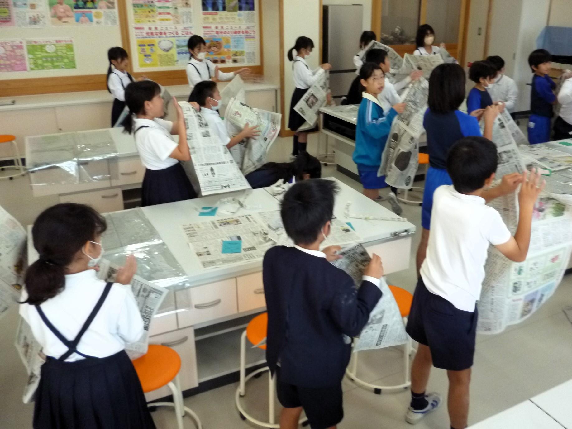先生の合図で新聞をちぎっていきます