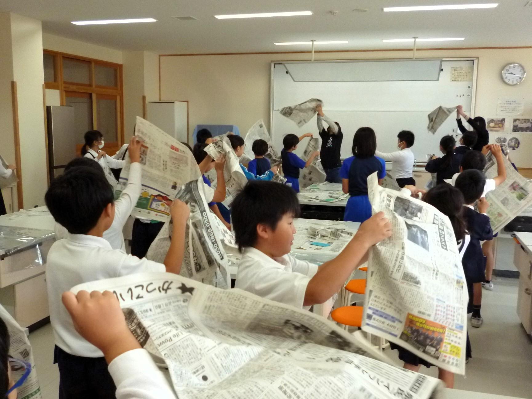 先生の合図に合わせて新聞をちぎっていきます 先生の合図に合わせて新聞をちぎっていきます